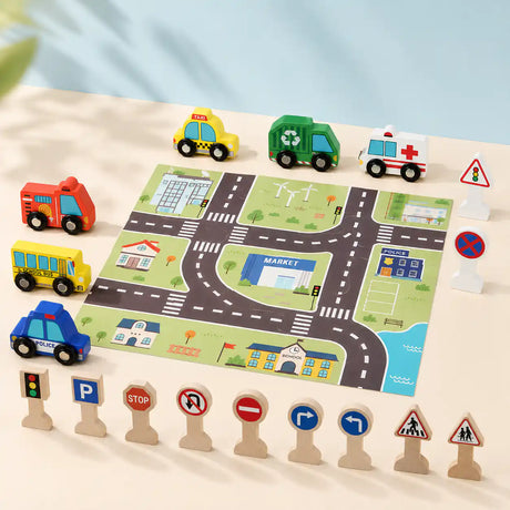 Child's hand placing a wooden school bus on the printed city play mat next to ambulance, police car, and traffic signs