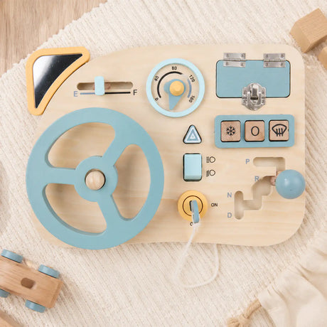 Wooden Montessori busy board mini pretend dashboard with steering wheel, gear shifter and dials on a cream background