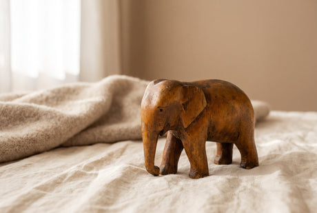 A well-loved heirloom wooden toy with a soft patina from years of use, resting on cream linen