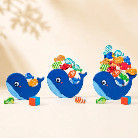 Wooden whale balancing toy shown in three sizes — small, medium and large