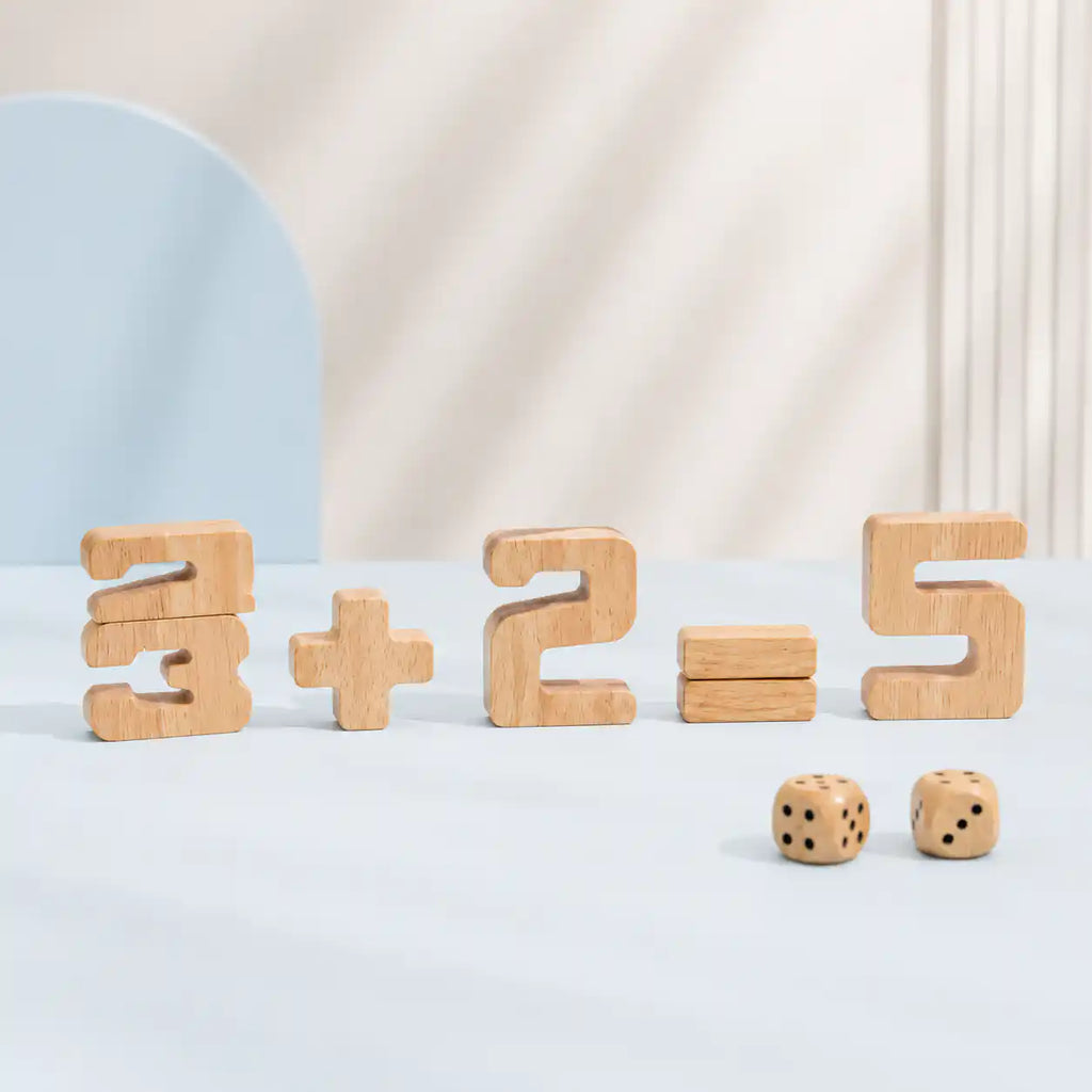 Young boy stacking a wooden 8 onto a number block tower with other natural wood numbers and dice spread across the table