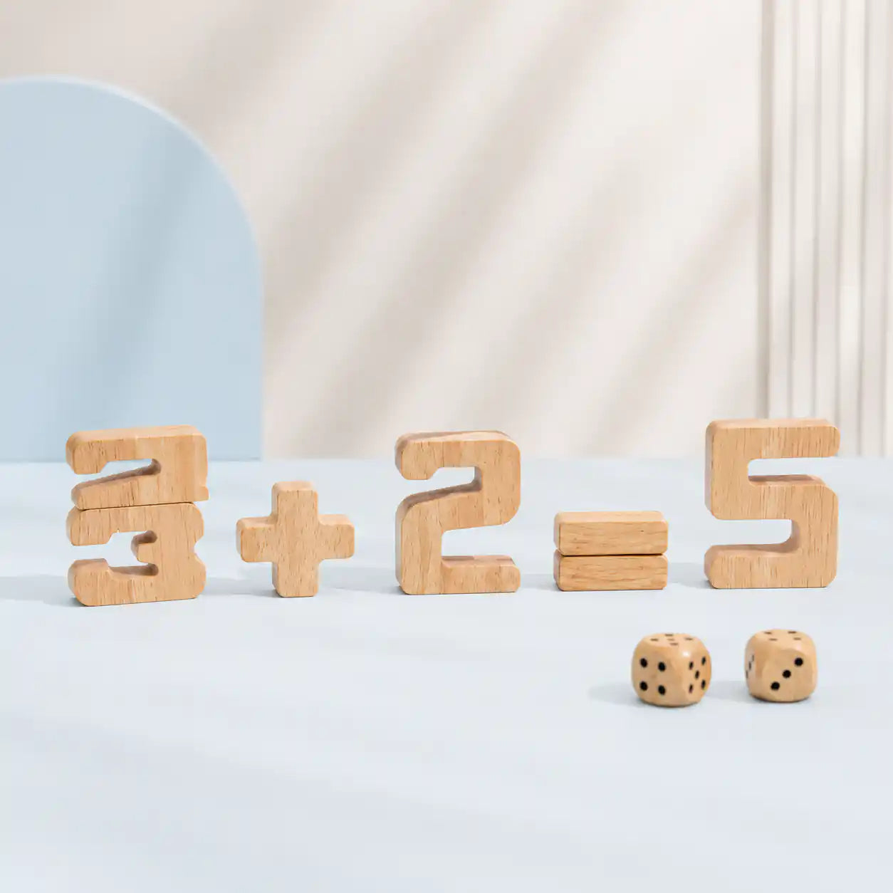 Young boy stacking a wooden 8 onto a number block tower with other natural wood numbers and dice spread across the table