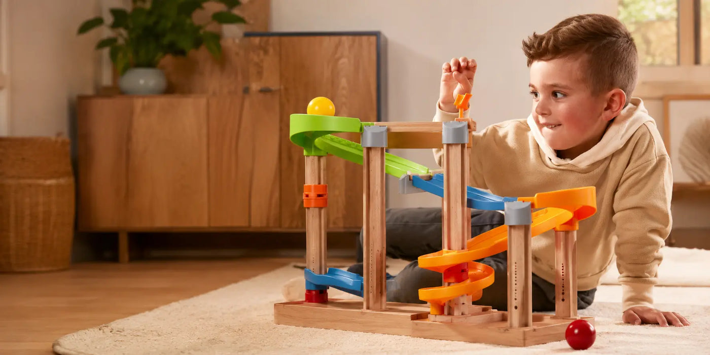 Children playing together with a wooden track toy in a warm, sunlit playroom — JuniSprouts Montessori-inspired toys for toddlers and preschoolers