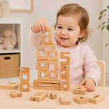 Preschool girl sitting at a white table playing with natural wood stacking number blocks, including a tall stack of 7 and 8