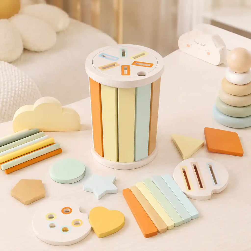 Toddler hands slotting a pastel wooden stick into the rectangular slot disc of the wooden Montessori sorting cylinder