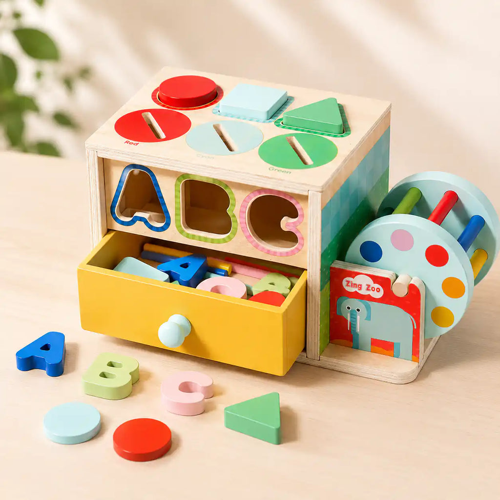 Wooden activity cube with yellow storage drawer open showing ABC letters and shape pieces neatly stored inside