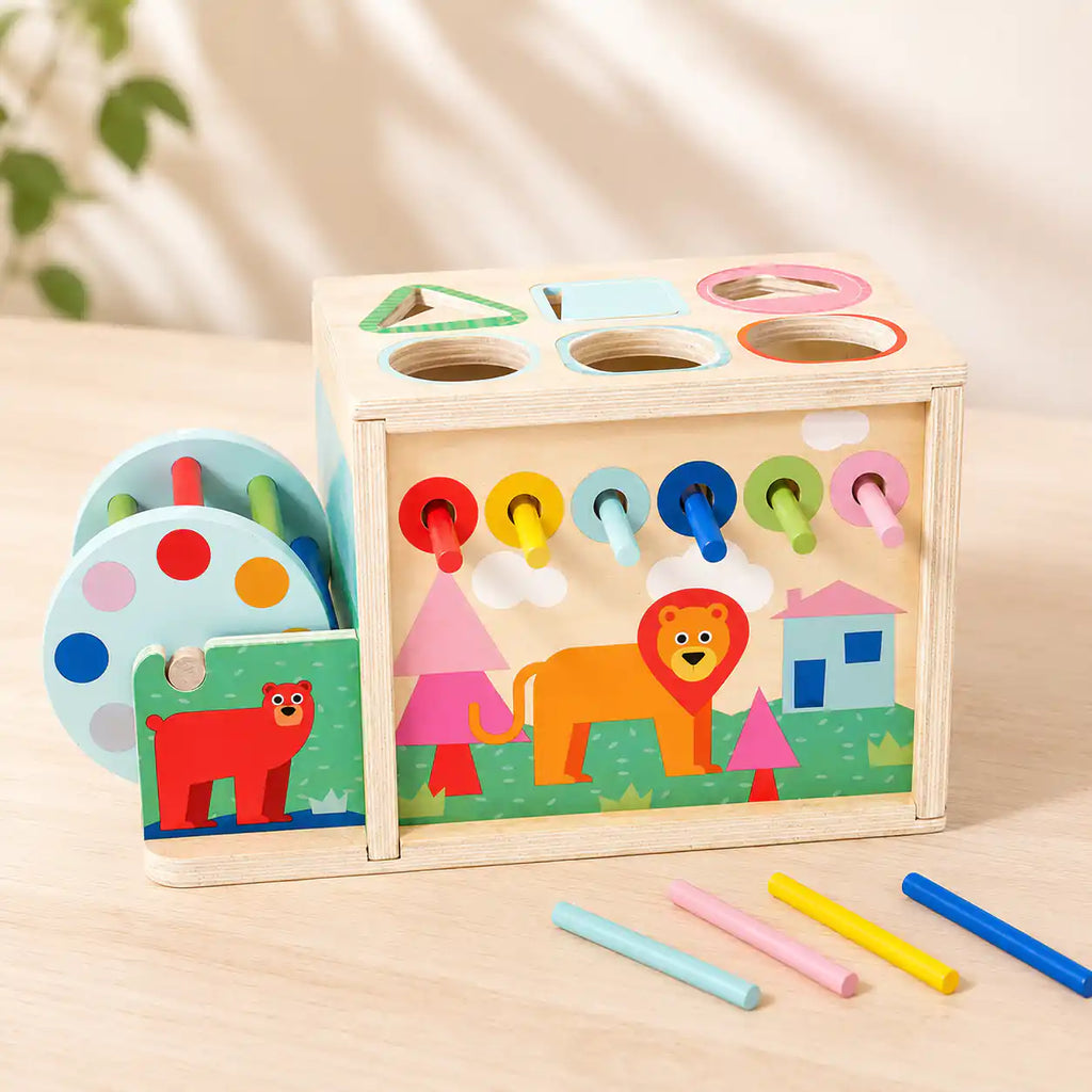 Back panel of wooden activity cube showing six rainbow pull-through sticks and a friendly lion illustration