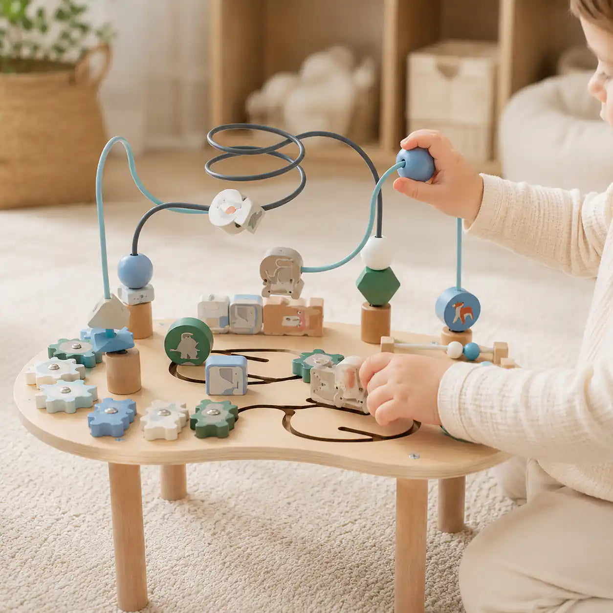 Toddler exploring the wooden 10-in-1 activity table on a soft playroom rug, manipulating bead maze and turning gears