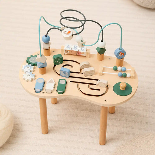 Close-up of wooden activity table top showing bead maze loops, spinning gears, and rotating alphabet blocks
