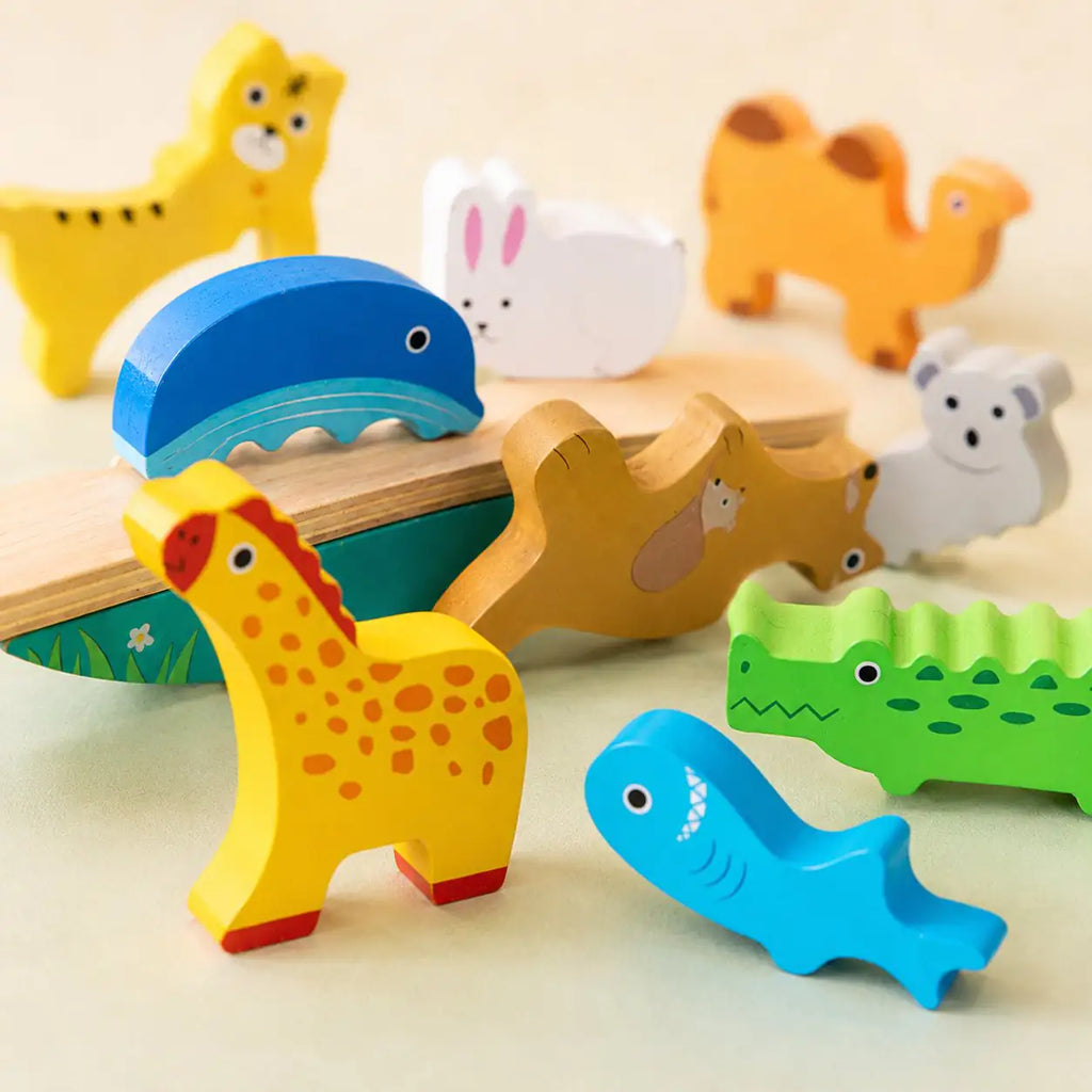 Toddler carefully stacking wooden animals into a wobbly tower on the Montessori balancing toy