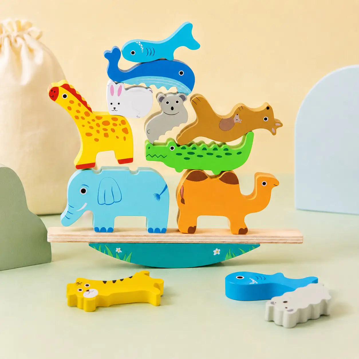 Wooden animal stacking toy packed into its soft cream cotton drawstring storage bag