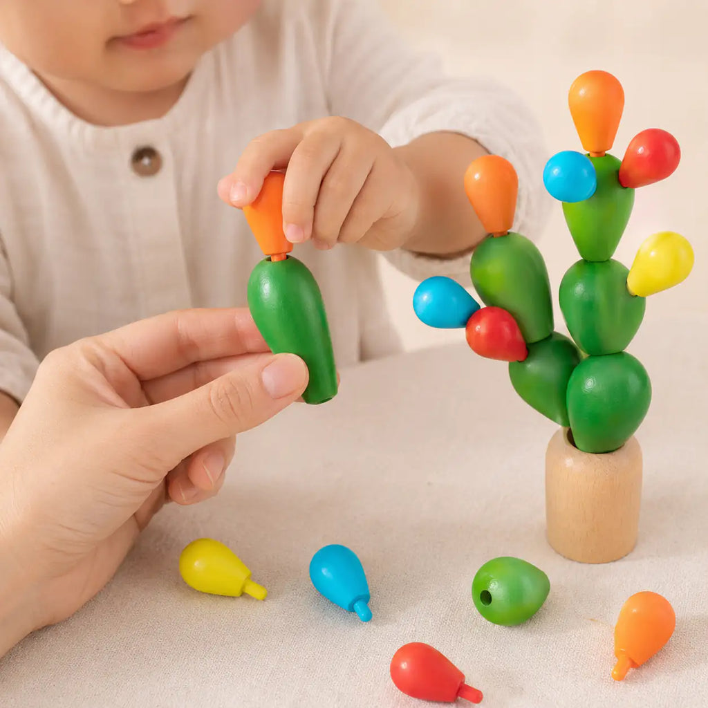 Wooden balancing cactus stacking toy styled on a calm Montessori-inspired playroom shelf
