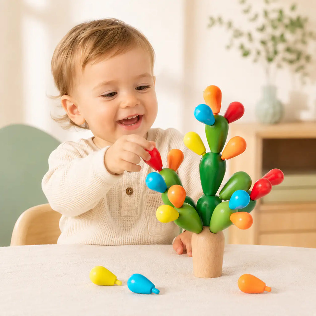 Toddler hands placing a wooden fruit onto the balancing cactus stacking toy