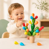 Toddler hands placing a wooden fruit onto the balancing cactus stacking toy