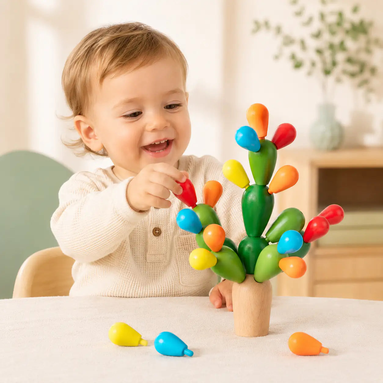 Toddler hands placing a wooden fruit onto the balancing cactus stacking toy