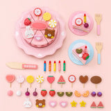 Full set of wooden birthday cake pretend play pieces laid out, including cake, plates, candles, fruit, and toppers