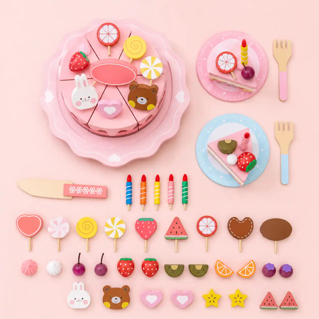 Full set of wooden birthday cake pretend play pieces laid out, including cake, plates, candles, fruit, and toppers