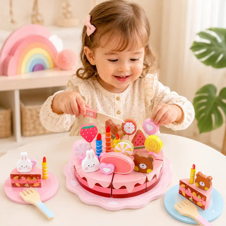 Young child smiling and decorating a wooden pretend play birthday cake on a nursery table