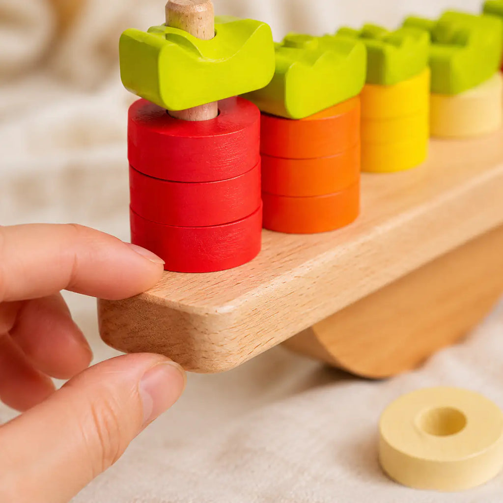 Numbered carrot tops matched to stacked wooden discs on the bunny balance scale