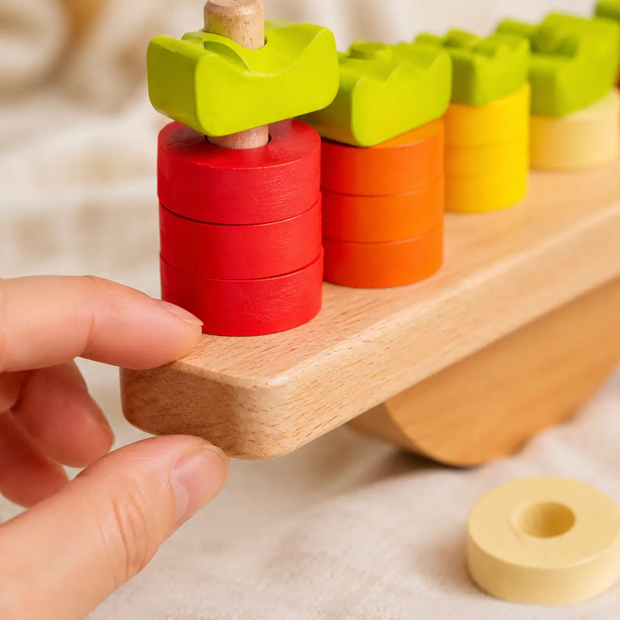 Numbered carrot tops matched to stacked wooden discs on the bunny balance scale
