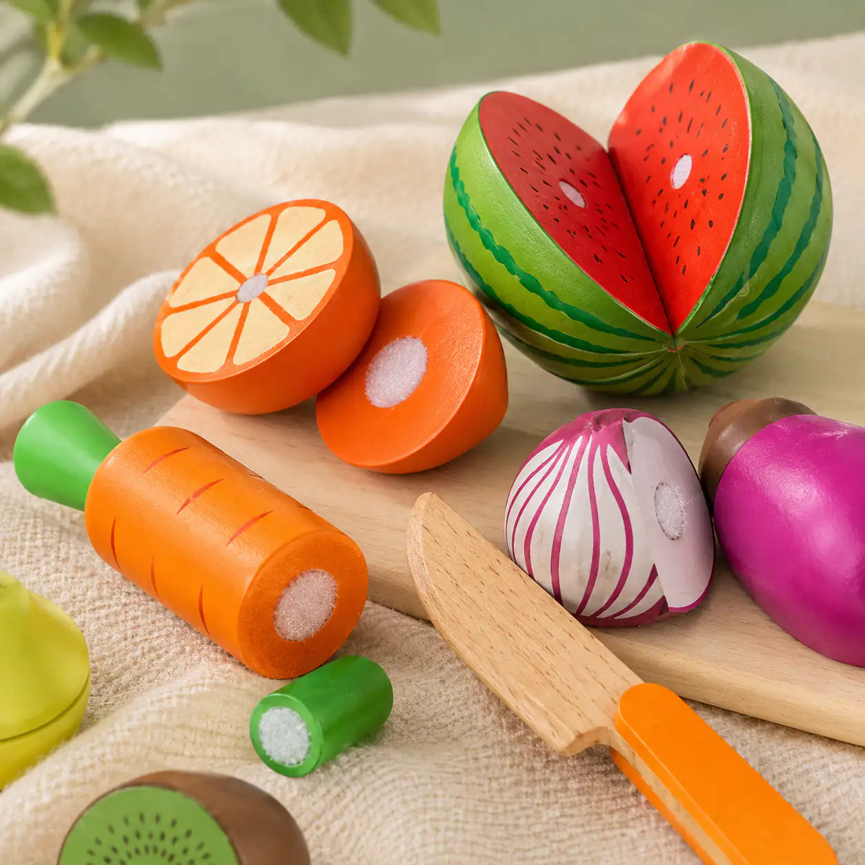 All 17 wooden fruits, vegetables and knife pieces from the cutting play set laid out
