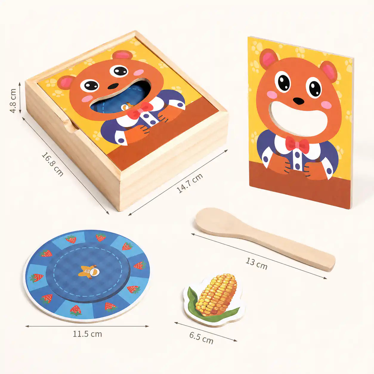 Wooden feed the bear toy showing dimensions of the storage box, bear face panel, wooden spoon, and strawberry-patterned plate for size reference