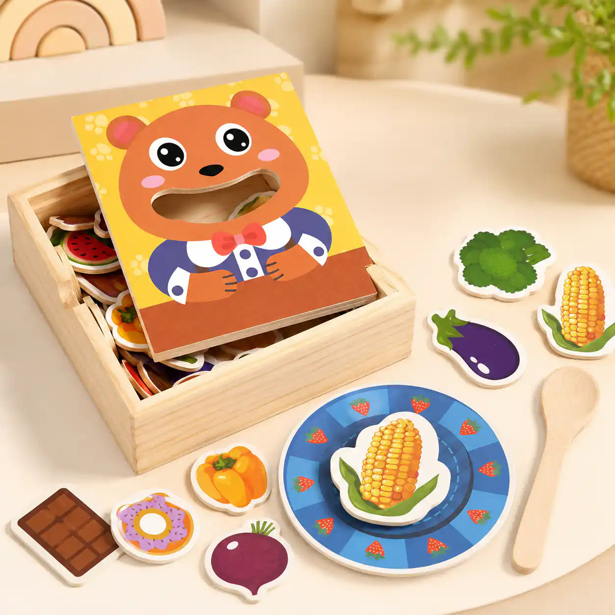 Wooden feed the bear toy styled on a neutral table with wooden food pieces and a strawberry plate in a calm Montessori-inspired playroom setting