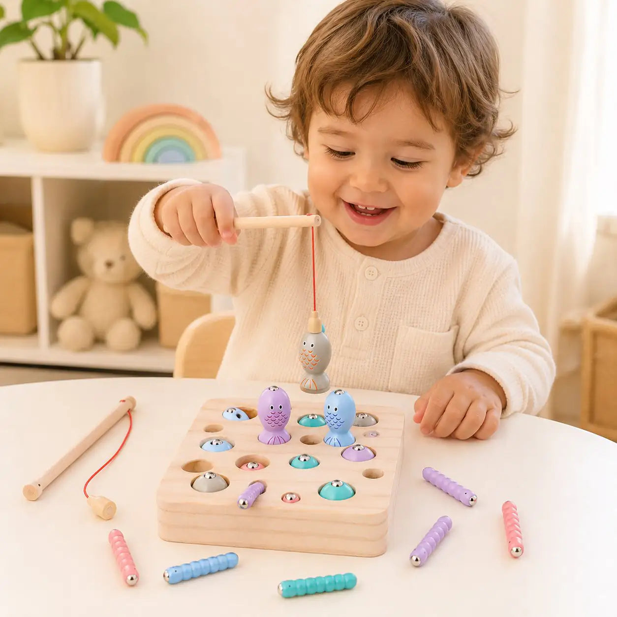 Preschooler lifting a pastel fish from the wooden magnetic fishing game during fine motor play