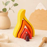 Wooden flame puzzle pieces arranged in an open layered configuration showing creative play possibilities