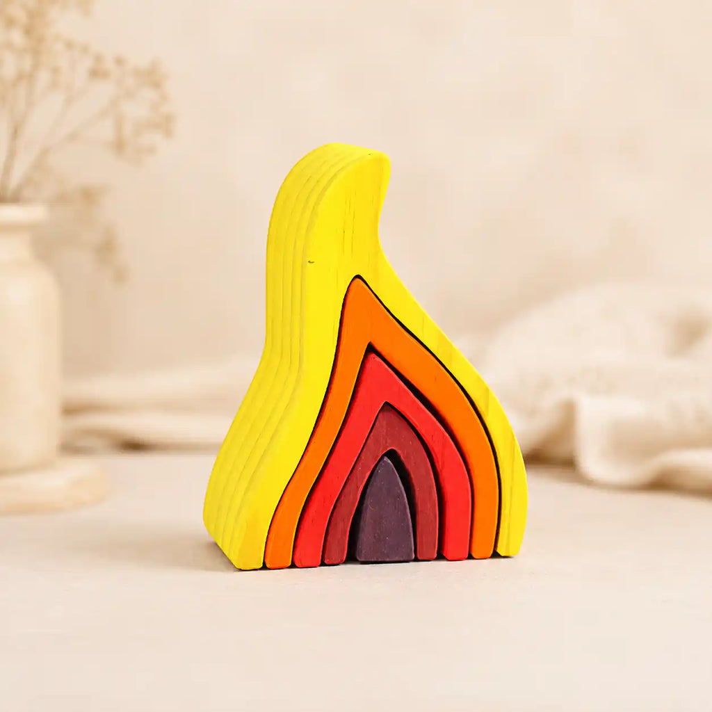 Wooden flame stacking puzzle in yellow, orange, red, and ember tones on a warm cream background, Waldorf-inspired for ages 4+