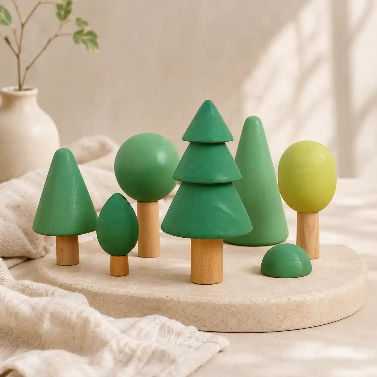 Wooden forest tree set arranged by height on a soft cream surface showing graduated tree sizes