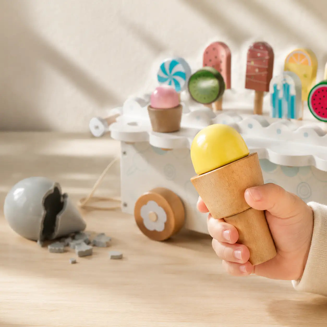 Close-up of the wooden ice cream cart flower-detail wheels and removable cone scoops