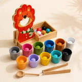 Wooden lion color sorter with 12 colored balls, cups, scoop and tongs on a cream background