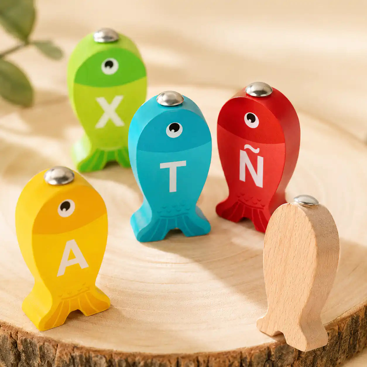 Close-up of colorful wooden alphabet fish with letters A, T, X, and Ñ
