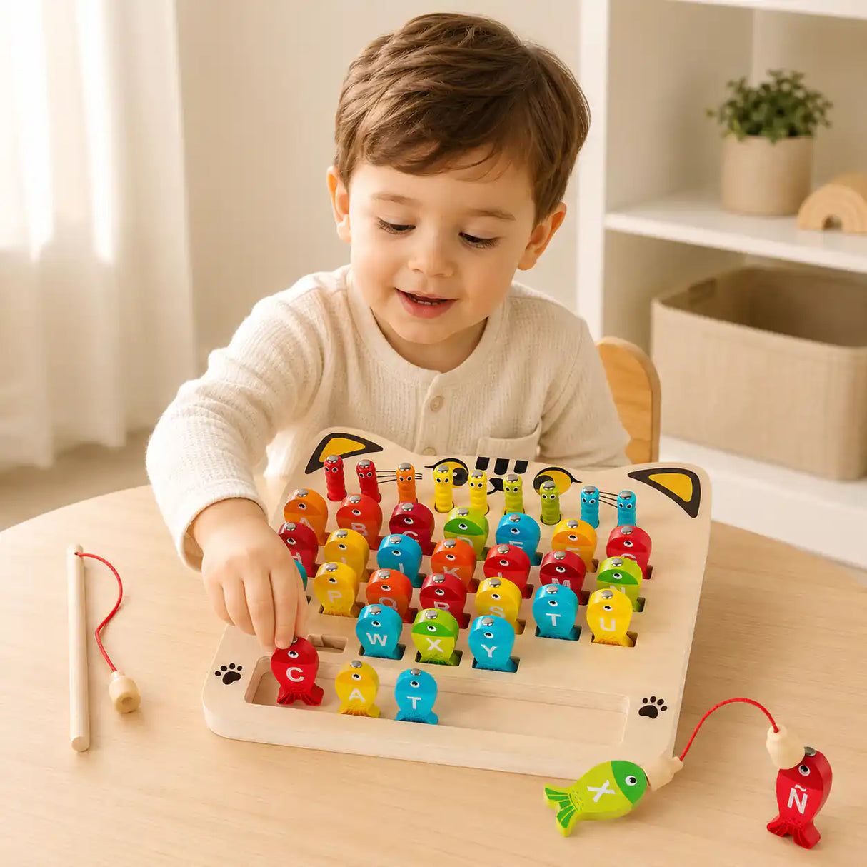 Toddler using the magnetic wand on the wooden alphabet fishing game