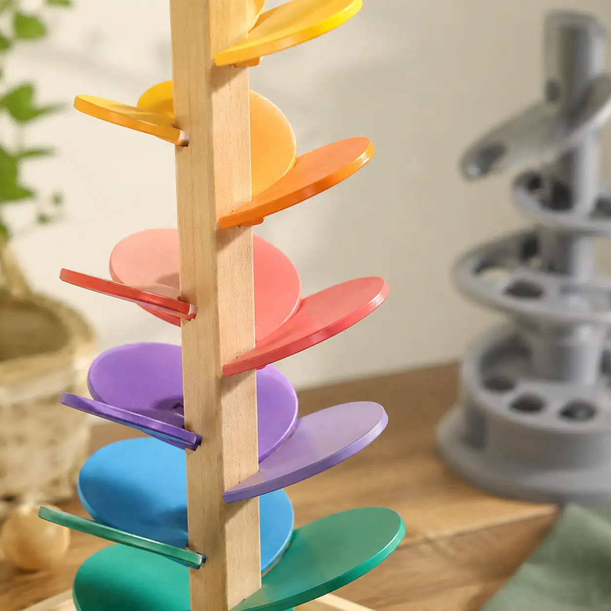 Rainbow wooden marble run music tree styled in a calm Montessori-inspired nursery corner