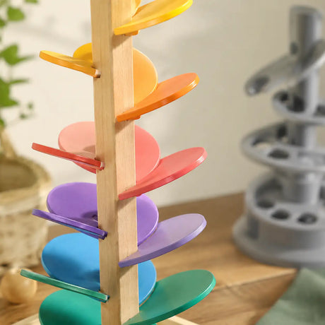 Rainbow wooden marble run music tree styled in a calm Montessori-inspired nursery corner