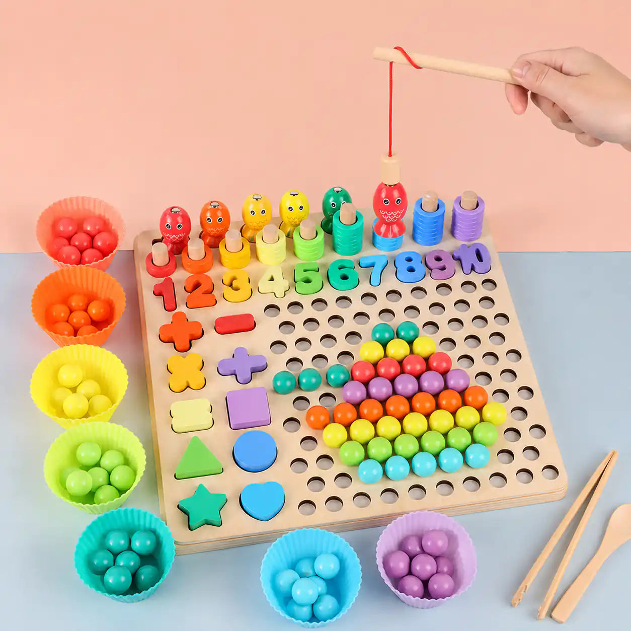 Hand using the magnetic wooden fishing rod to lift a character peg above the wooden Montessori 10-in-1 learning board with beads, numbers, and sorting bowls