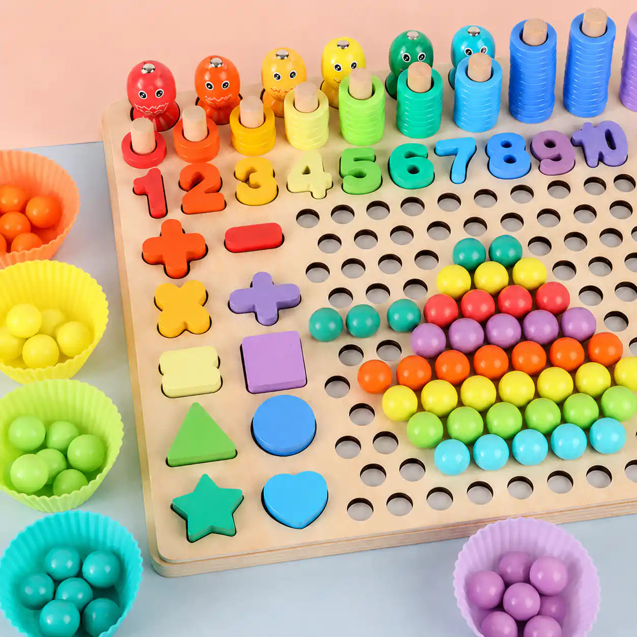Close-up of the wooden Montessori learning board showing rainbow numbers 1 to 10, math operation symbols, shape pieces, and counting tower pegs with stacked rings
