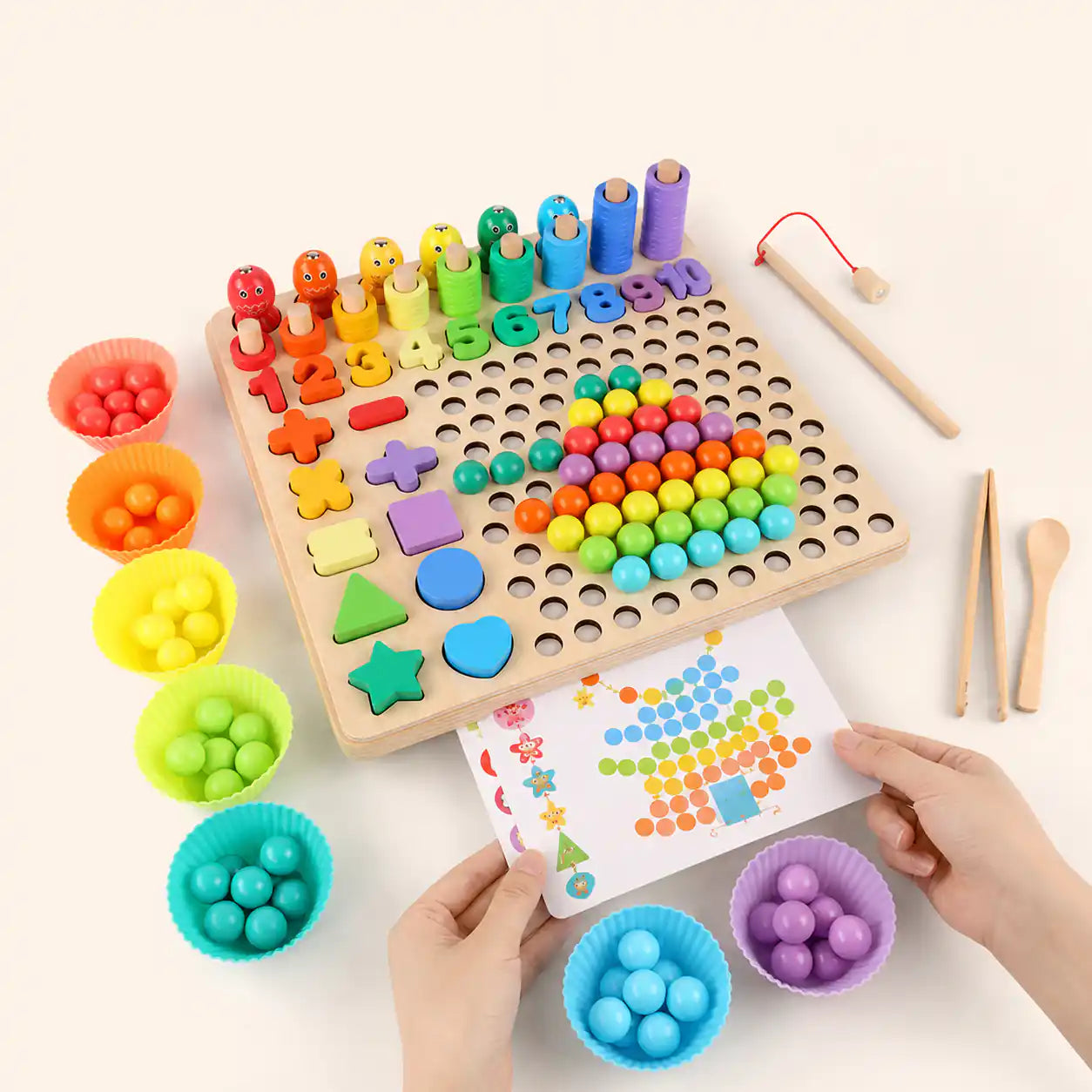 Hands holding a colorful pattern card next to the wooden Montessori 10-in-1 learning board with bead grid, numbers, and sorting bowls