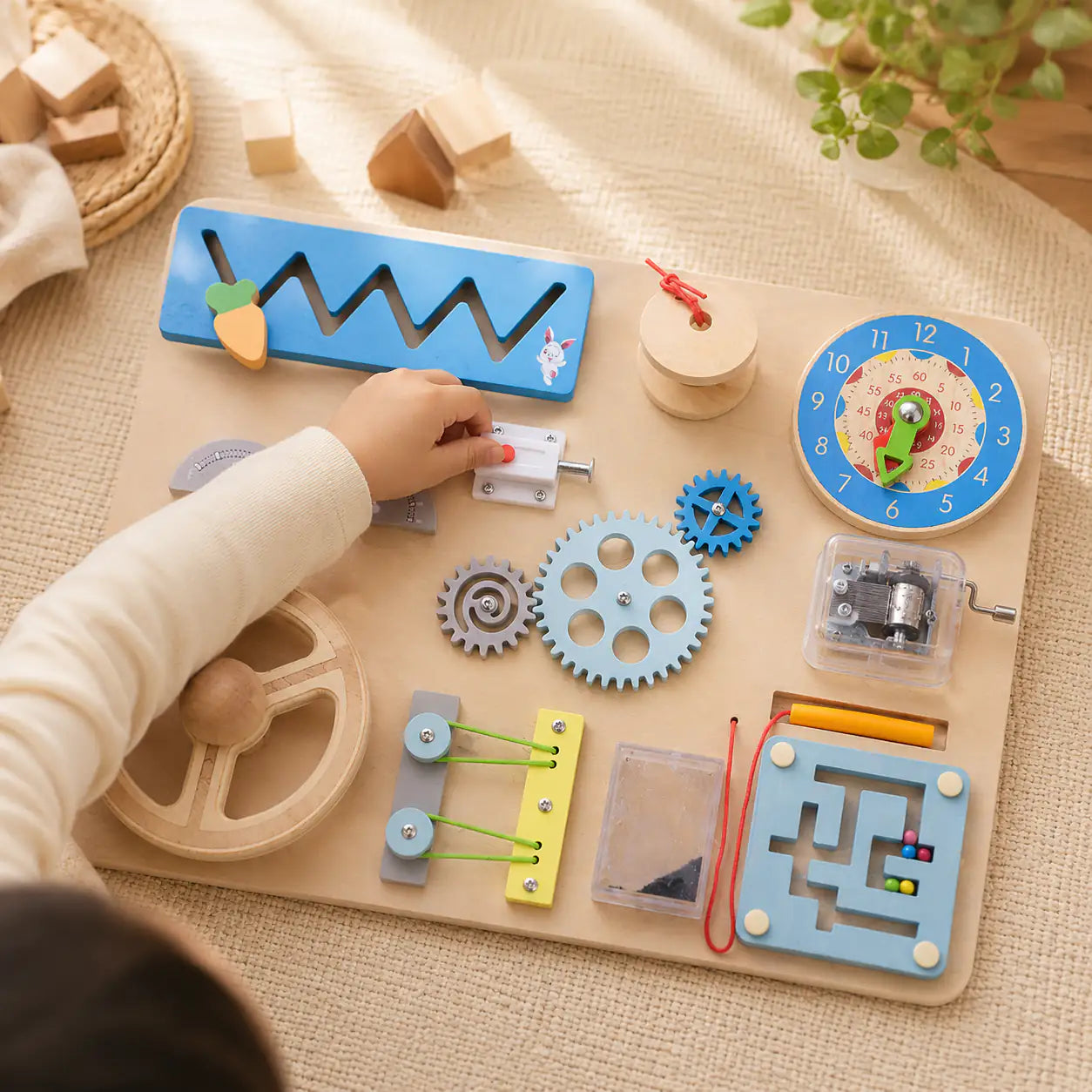 Toddler hands turning wooden gears and exploring the Montessori busy board activities