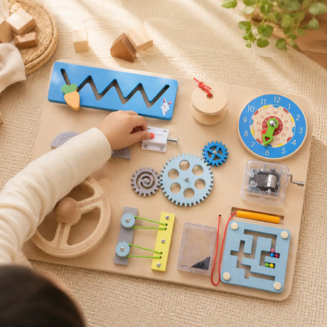 Toddler hands turning wooden gears and exploring the Montessori busy board activities