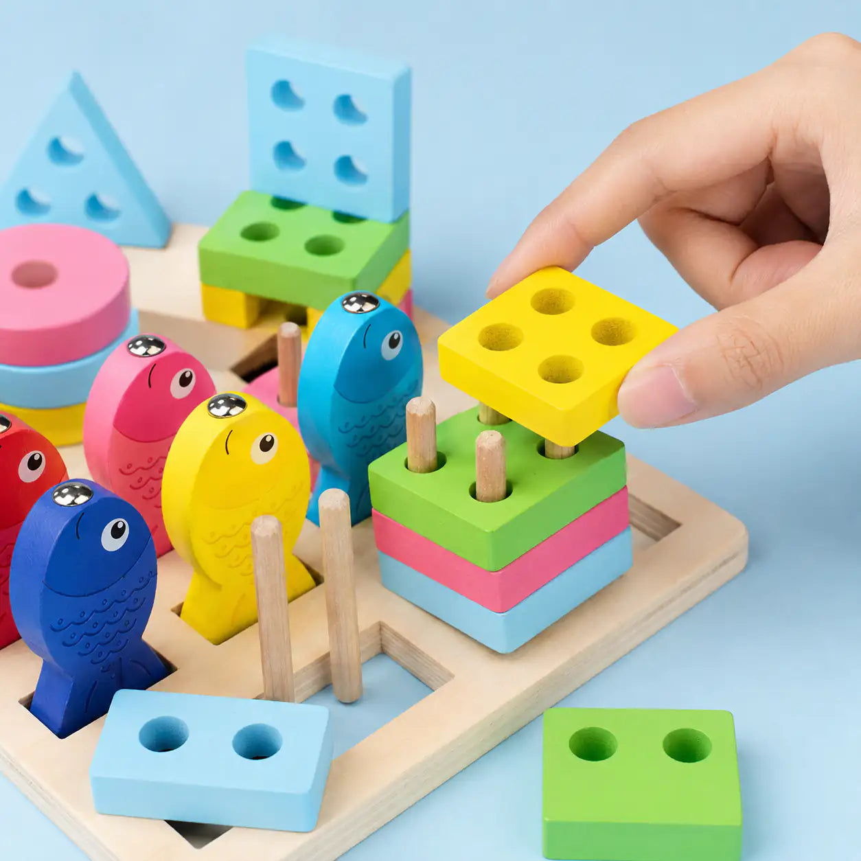 Wooden Montessori shape sorter and magnetic fishing board styled in a calm pastel playroom