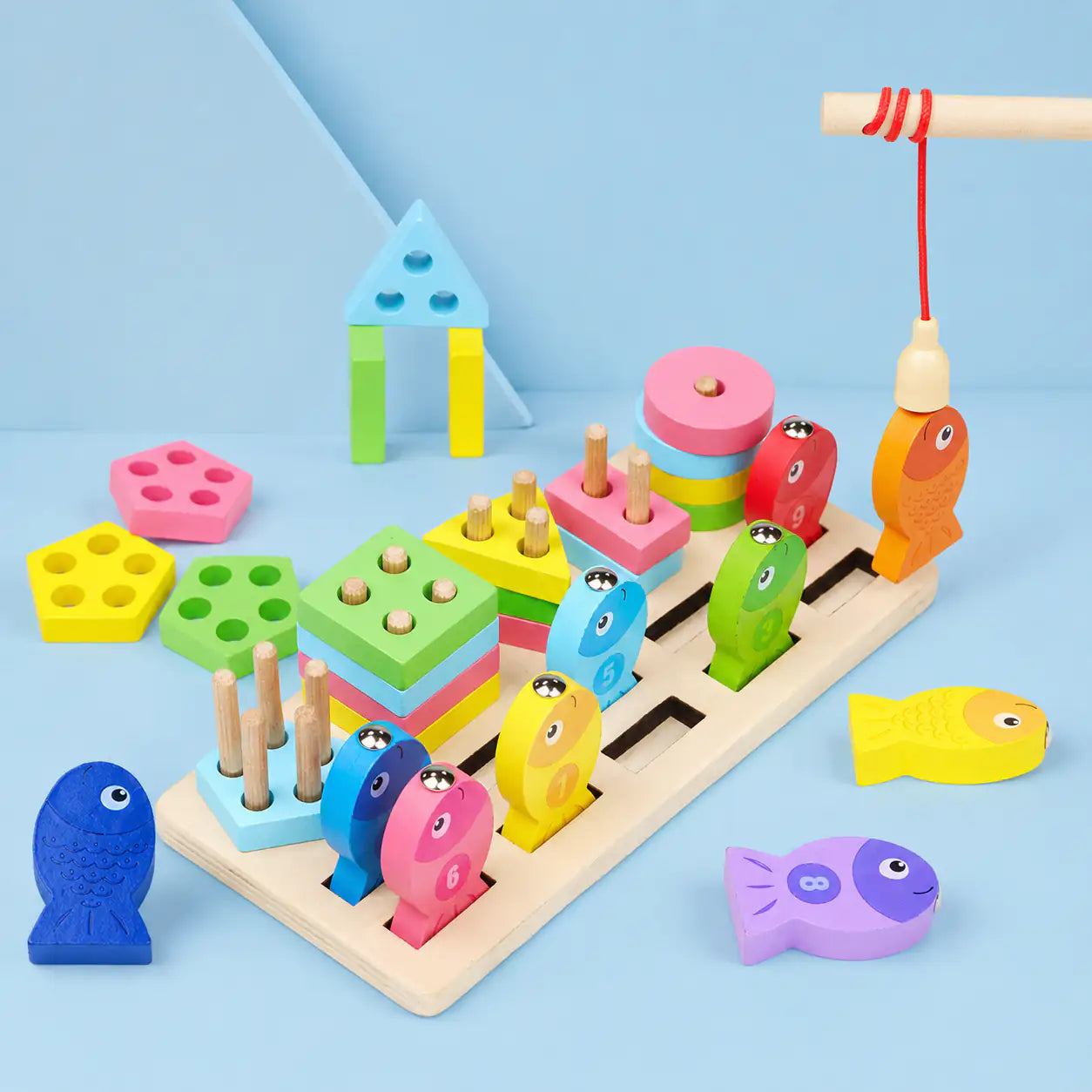 Wooden Montessori shape sorter and magnetic fishing board with pastel shapes, pegs and numbered fish on a cream background