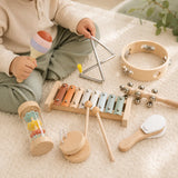 Toddler hands playing the wooden xylophone with two mallets from the musical instrument set