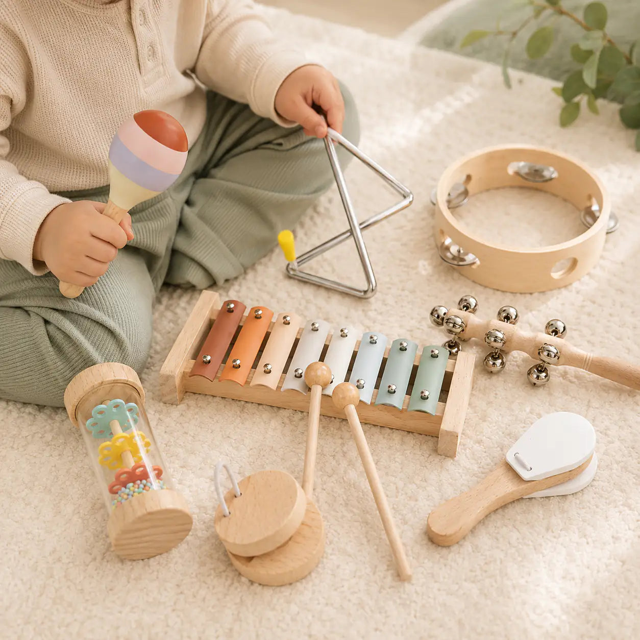 Toddler hands playing the wooden xylophone with two mallets from the musical instrument set