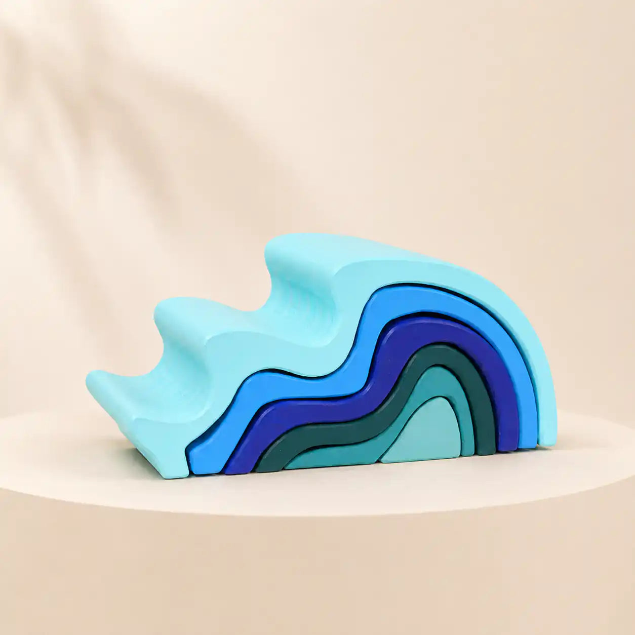 Wooden ocean wave stacker partially nested showing each curved layer fitting into the next