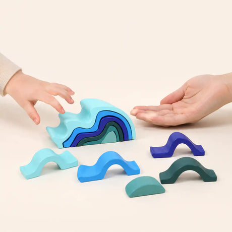 Close-up of a single wooden wave stacker piece showing painted finish and smooth curve