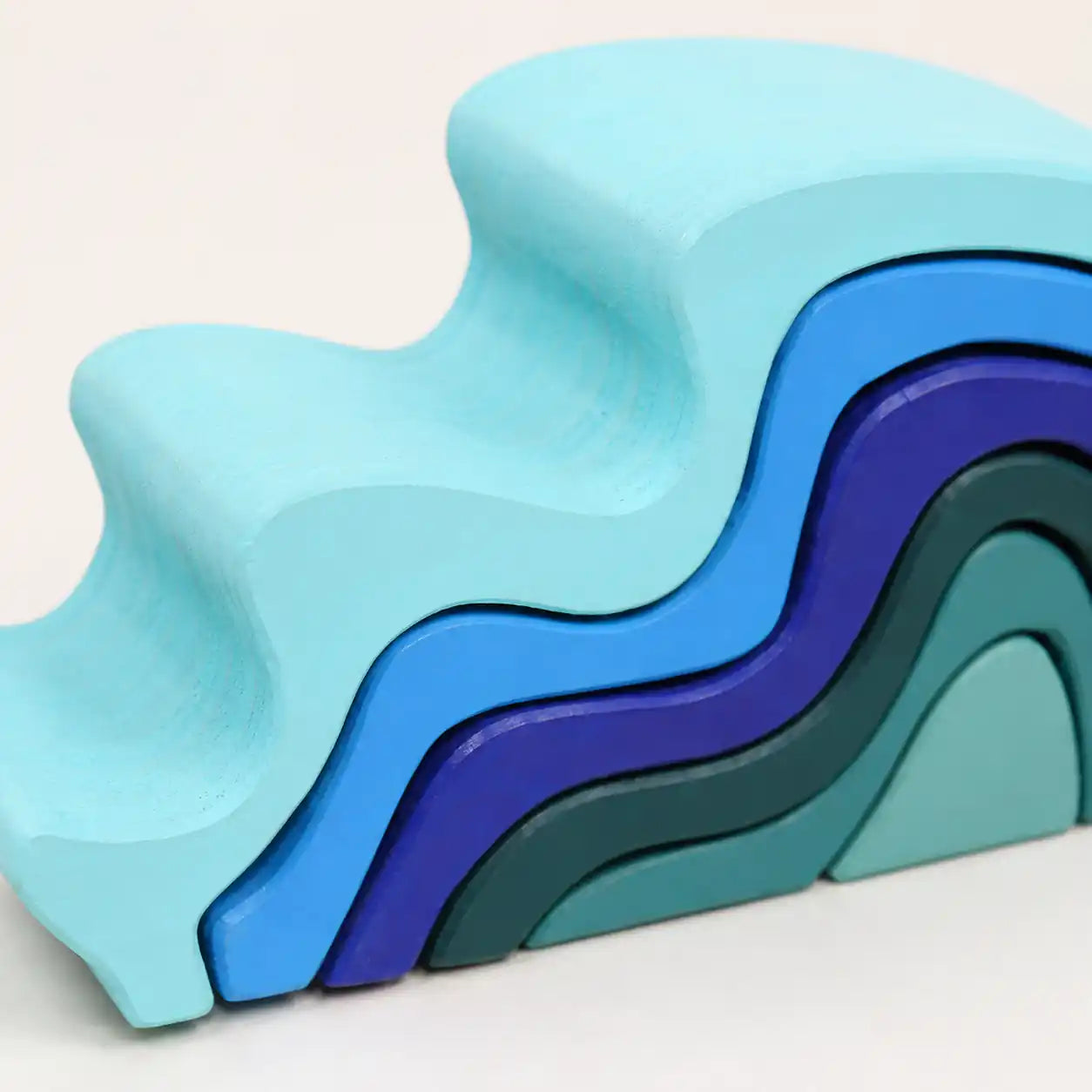 Side view of assembled wooden ocean wave stacker showing curved silhouette