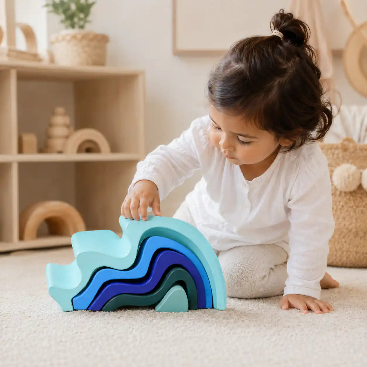 Wooden ocean wave stacker styled in a warm nursery play scene